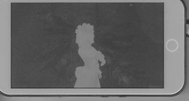 Flatbed scan of the e-paper panel showing a clean white silhouette with detailed hair outline on a solid black background, a paused frame of the Bad Apple video